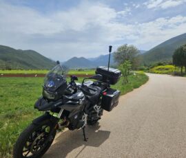 A BMW F800GS rental motorcycle from MotoGreece parked on a countryside road in Greece